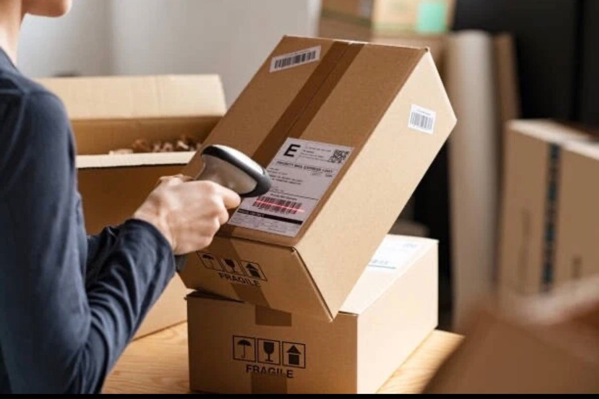 Warehouse worker scanning barcode label on shipping box